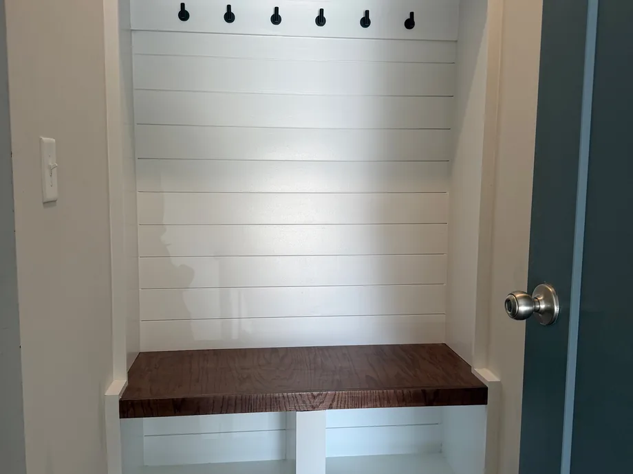 Custom built mudroom bench with cubbies, coat hooks and a shiplap back